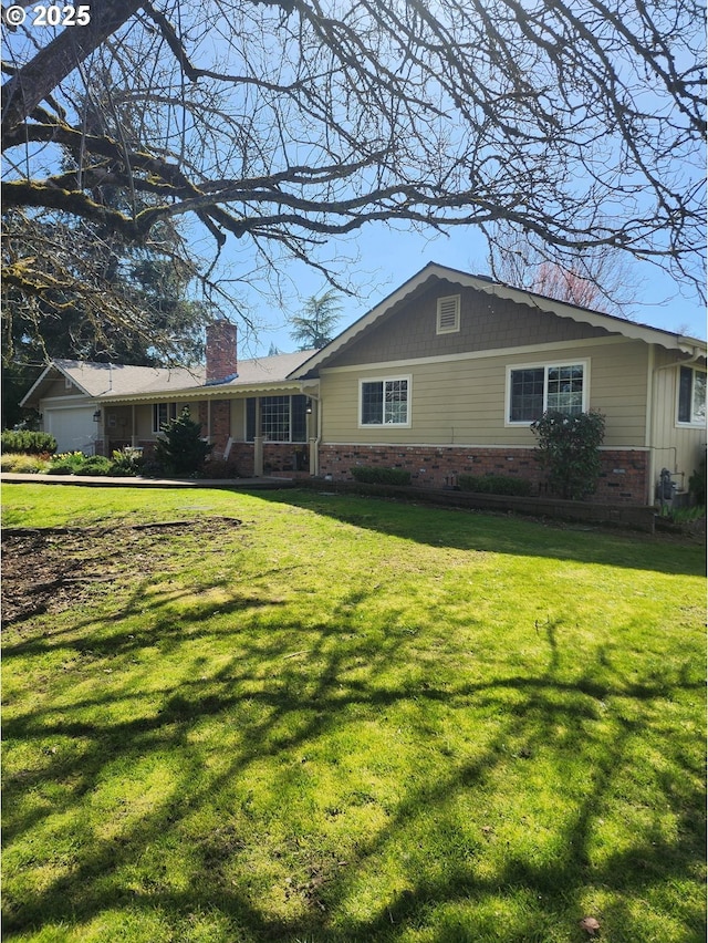 view of front of property with brick siding, a chimney, and a front lawn