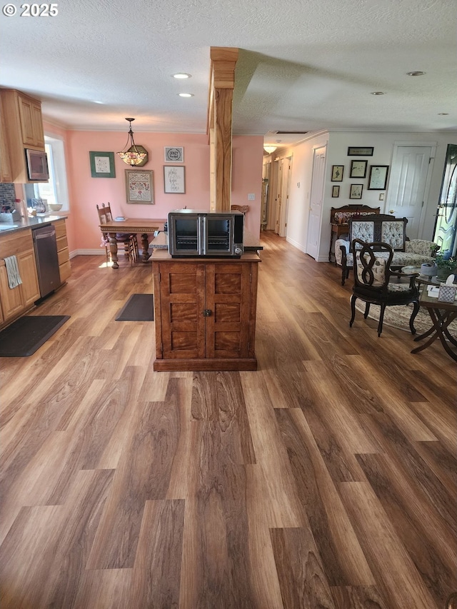 kitchen featuring stainless steel appliances, a textured ceiling, and wood finished floors