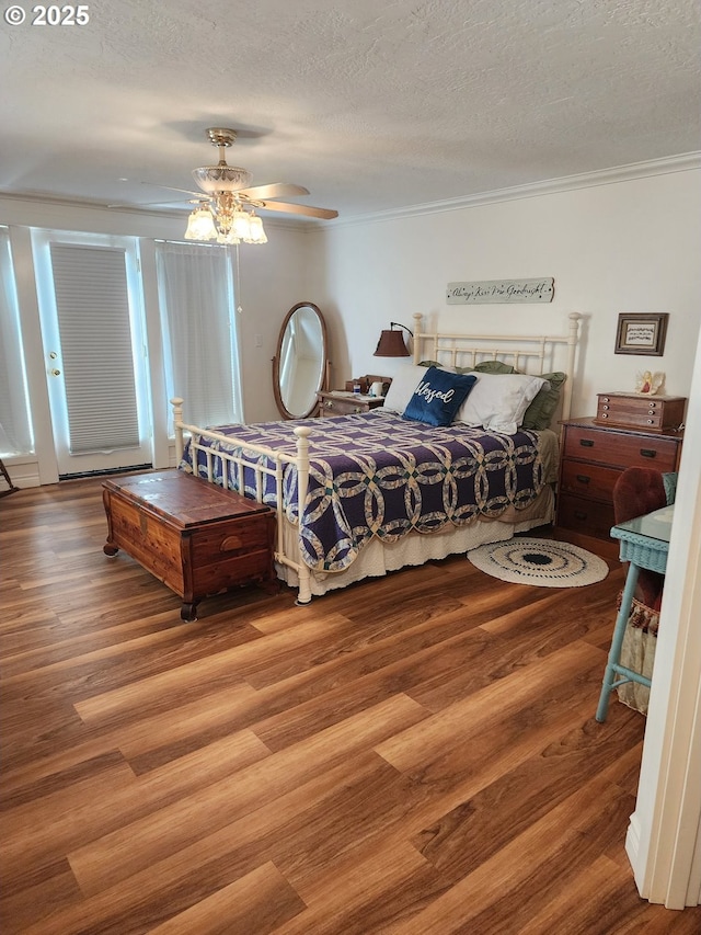 bedroom with a ceiling fan, wood finished floors, and a textured ceiling