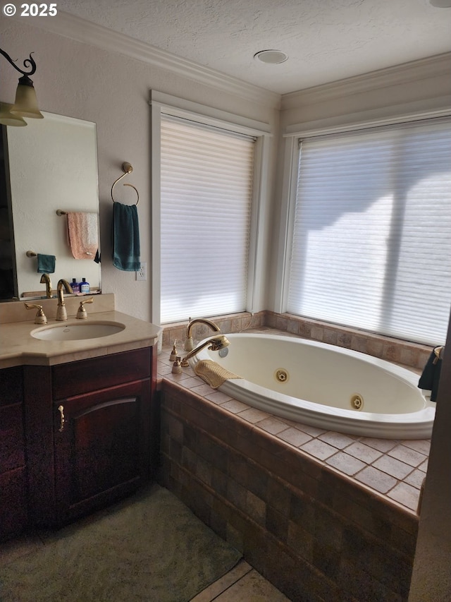 full bath featuring vanity, a whirlpool tub, tile patterned flooring, a textured ceiling, and crown molding