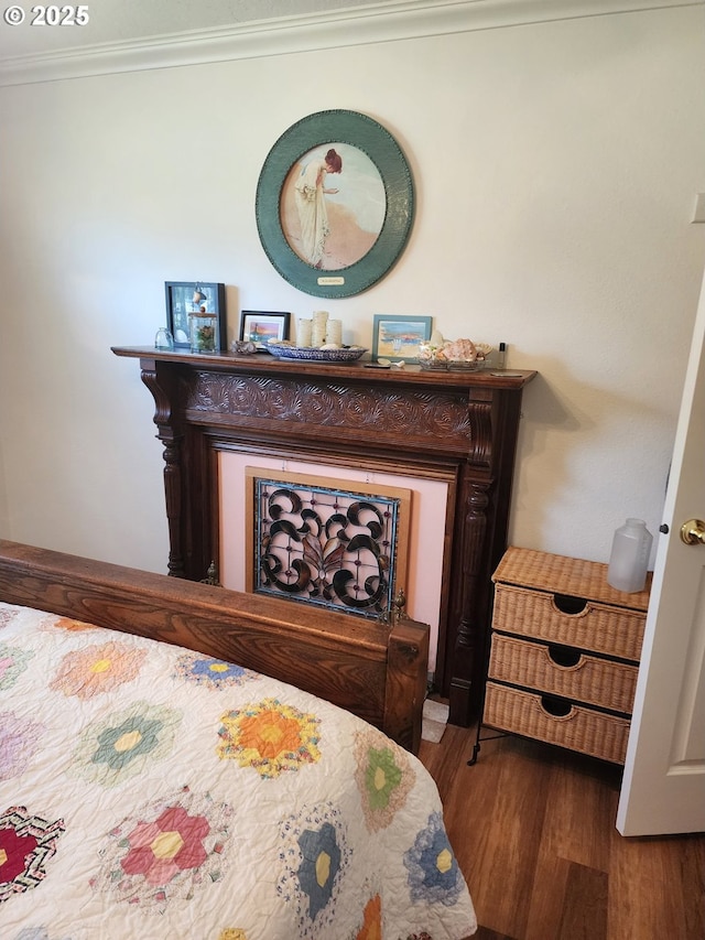 bedroom featuring crown molding and wood finished floors