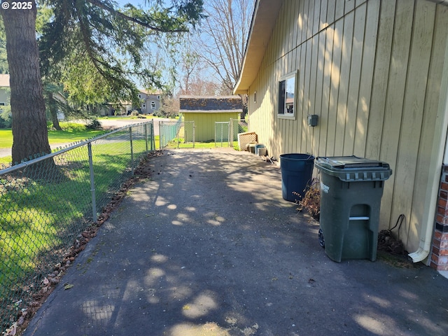 view of home's exterior with an outbuilding, driveway, and fence