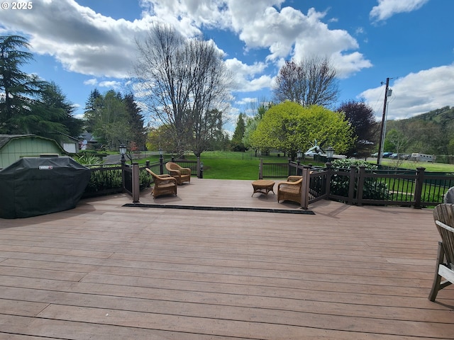deck with a grill and a lawn