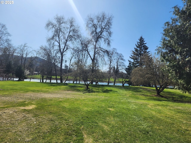 surrounding community with a lawn and a water view