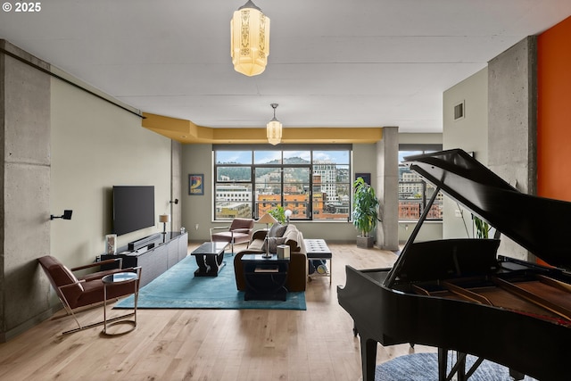 living area with visible vents and wood finished floors