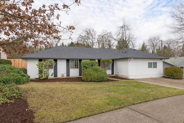 ranch-style house with a shingled roof, driveway, a front lawn, and fence