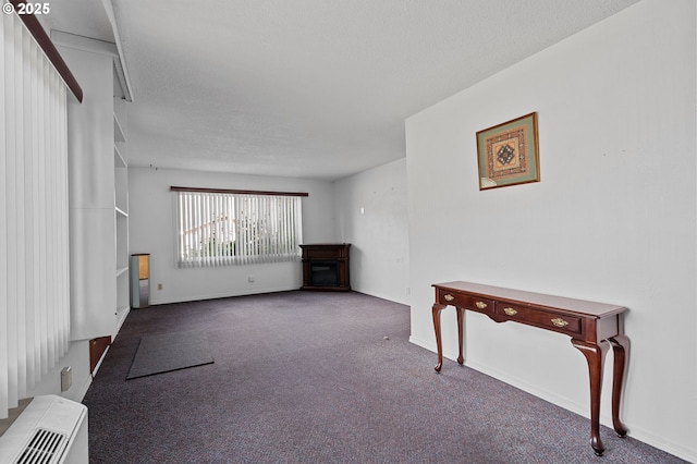 living room featuring carpet flooring, a textured ceiling, and baseboards