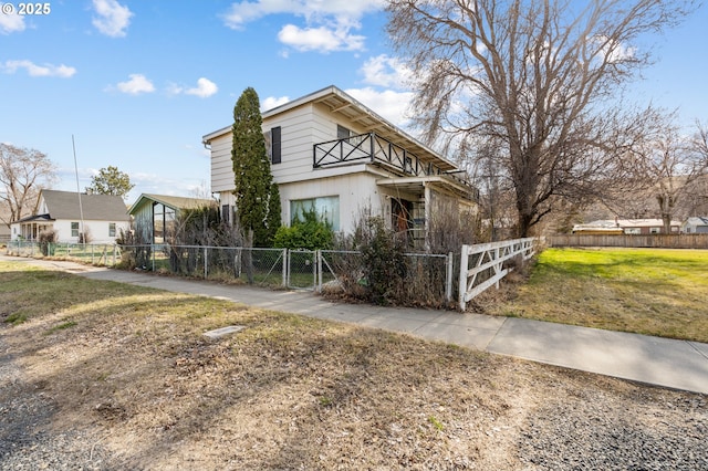 view of front of property featuring a fenced front yard, a gate, and a front lawn