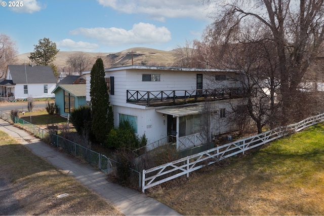 view of front of house with a fenced front yard and a mountain view