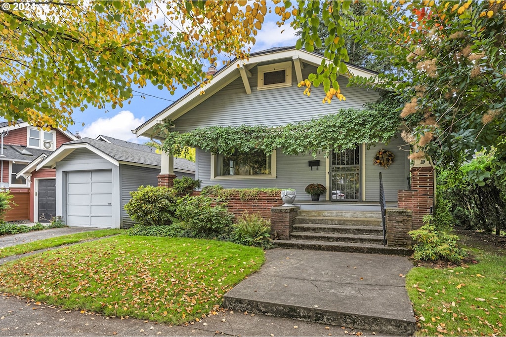 bungalow-style house featuring covered porch, a garage, and a front yard