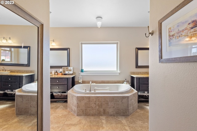 bathroom featuring tiled bath, plenty of natural light, dual bowl vanity, and tile floors