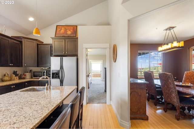 kitchen featuring appliances with stainless steel finishes, decorative light fixtures, and light hardwood / wood-style flooring