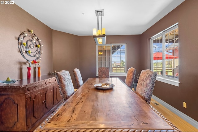 dining space featuring a notable chandelier and light wood-type flooring