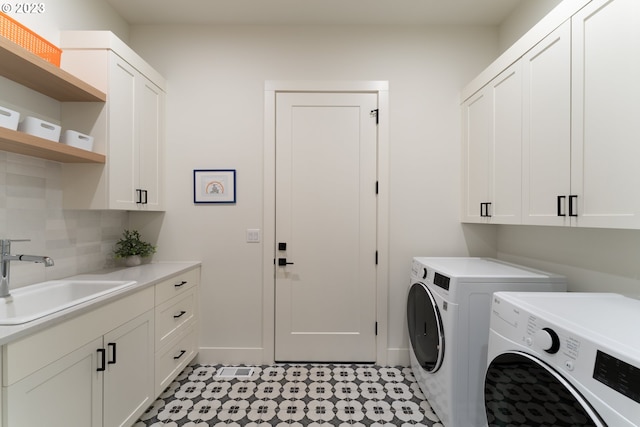 clothes washing area featuring independent washer and dryer, sink, cabinets, and light tile floors