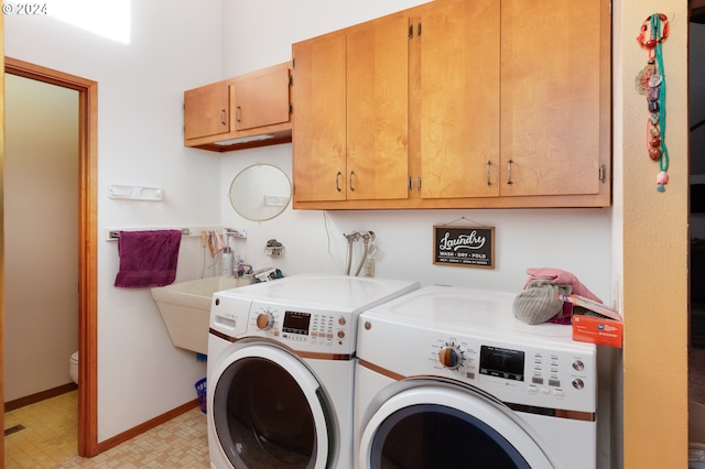 washroom featuring cabinets, sink, and washing machine and dryer