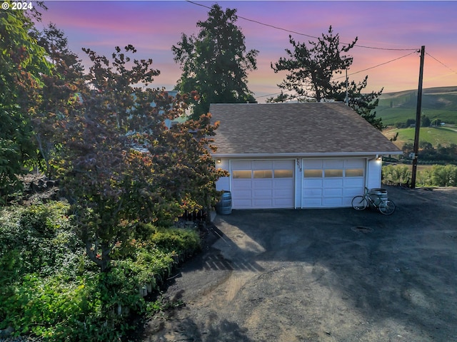 view of garage at dusk