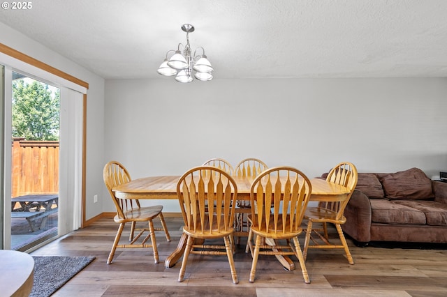 1062 Applegate Pl, Harrisburg, OR 97446 - dining space with a chandelier, wood finished floors, baseboards, and a textured ceiling