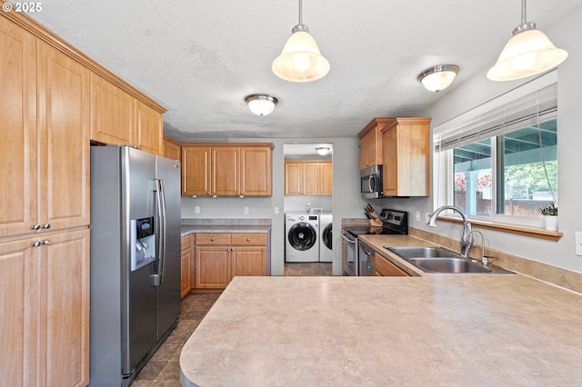 1062 Applegate Pl, Harrisburg, OR 97446 - kitchen with stainless steel appliances, a sink, washer and dryer, a peninsula, and light countertops
