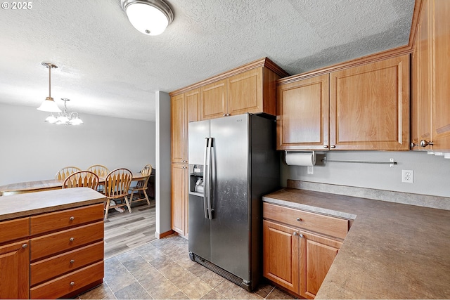 1062 Applegate Pl, Harrisburg, OR 97446 - kitchen featuring stainless steel refrigerator with ice dispenser, a chandelier, a textured ceiling, decorative light fixtures, and brown cabinetry
