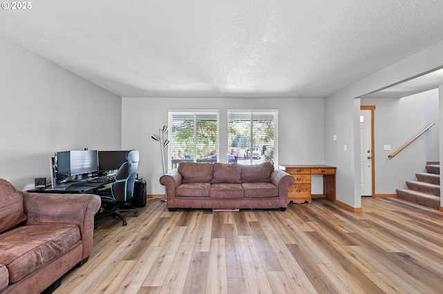 1062 Applegate Pl, Harrisburg, OR 97446 - living room featuring light wood finished floors, a desk, stairs, baseboards, and a textured ceiling