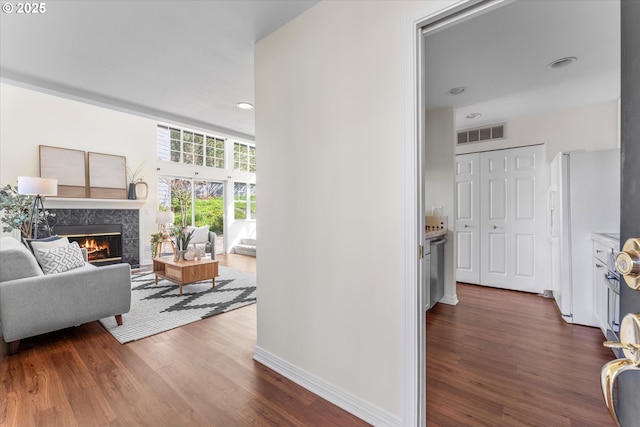hallway with dark wood-type flooring, visible vents, baseboards, and recessed lighting