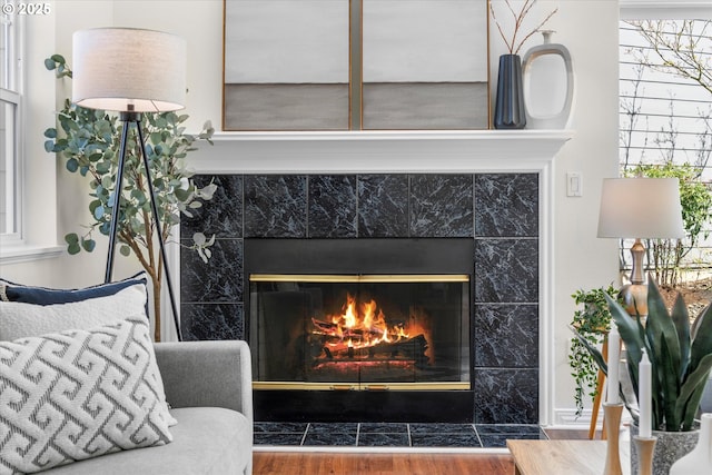 interior details featuring a tile fireplace and wood finished floors