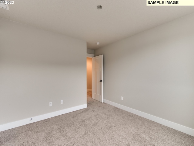 spare room with light colored carpet