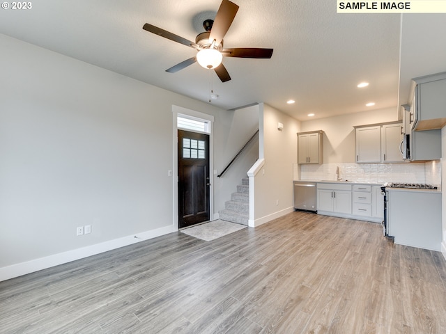 kitchen featuring appliances with stainless steel finishes, ceiling fan, sink, light hardwood / wood-style flooring, and gray cabinets