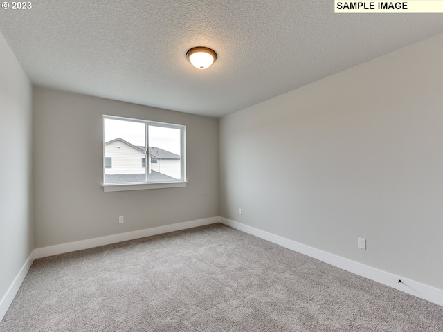 unfurnished room featuring a textured ceiling and light colored carpet