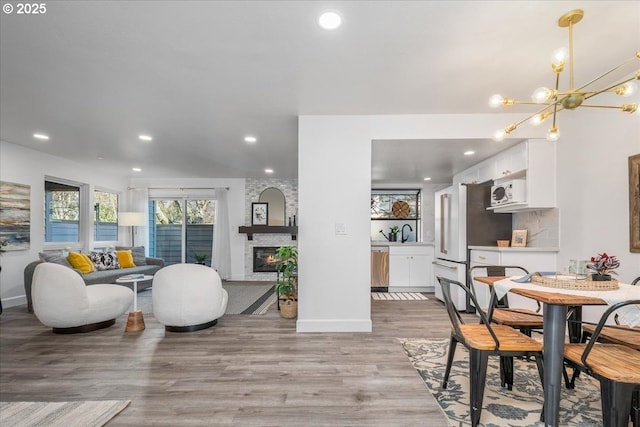 dining area with recessed lighting, a fireplace, light wood finished floors, and a chandelier