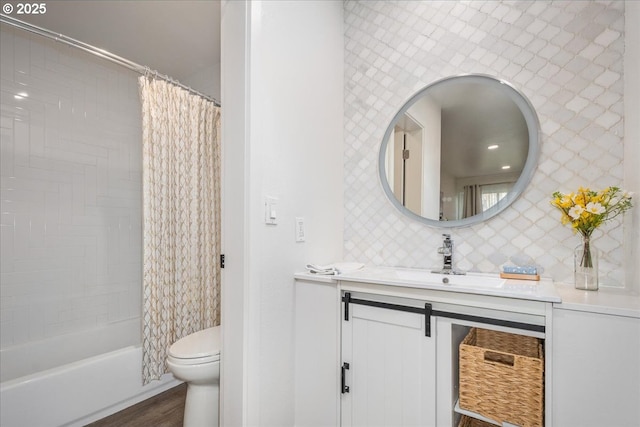 bathroom featuring toilet, decorative backsplash, wood finished floors, shower / bath combination with curtain, and vanity