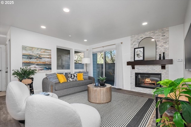 living area with a fireplace, recessed lighting, and wood finished floors