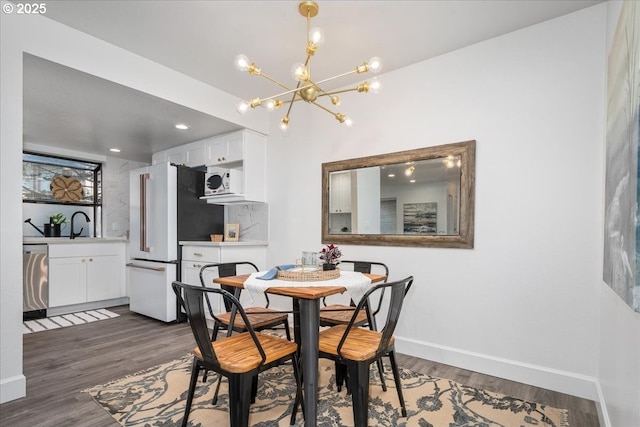 dining space with recessed lighting, baseboards, an inviting chandelier, and dark wood-style flooring