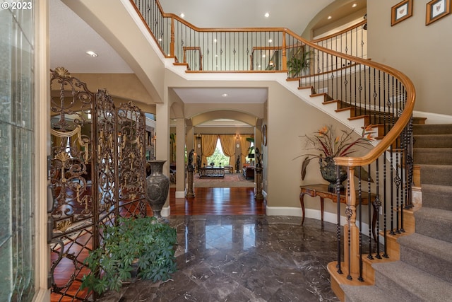 foyer entrance featuring a notable chandelier, a high ceiling, and dark hardwood / wood-style floors