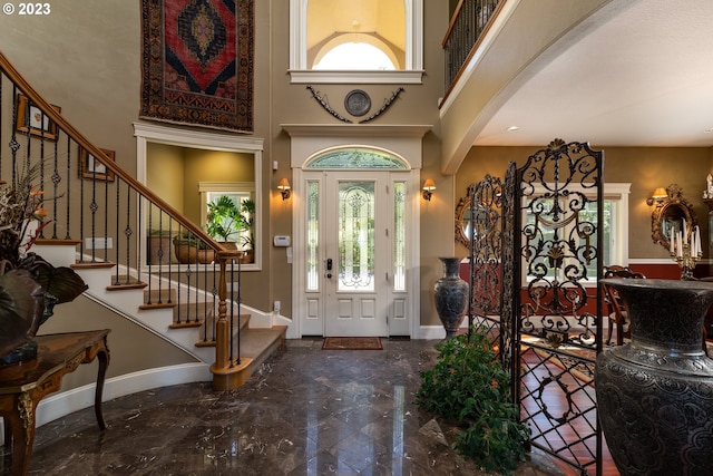 foyer entrance with a high ceiling and dark tile floors