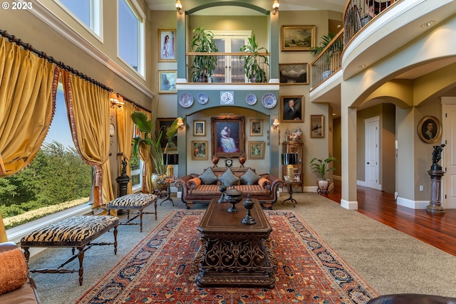 interior space with a healthy amount of sunlight, dark wood-type flooring, and a high ceiling