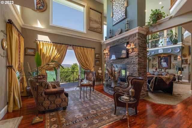 living room with a fireplace, dark wood-type flooring, and a towering ceiling