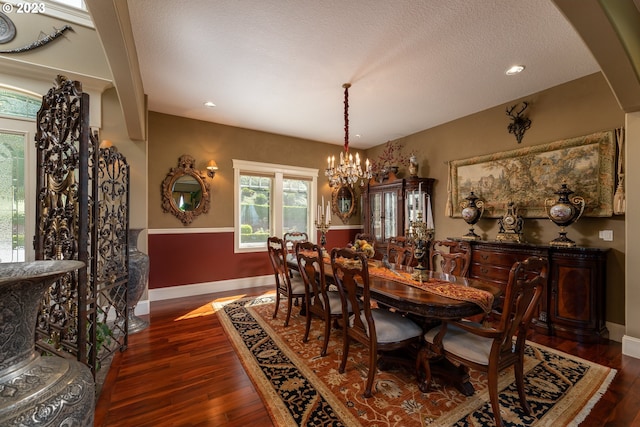 dining room with a notable chandelier, a textured ceiling, and dark hardwood / wood-style flooring