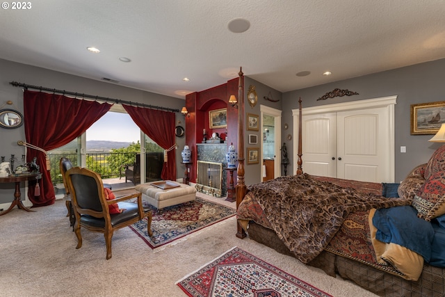 carpeted bedroom with a textured ceiling and access to exterior