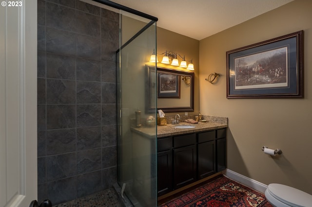 bathroom featuring toilet, large vanity, and walk in shower