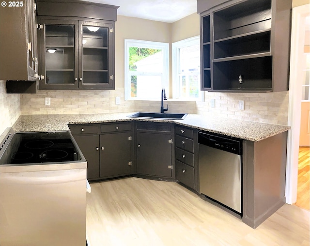 703 Cowlitz Way, Kelso, WA 98626 - kitchen featuring dishwasher, light wood-style floors, electric stove, decorative backsplash, and glass insert cabinets