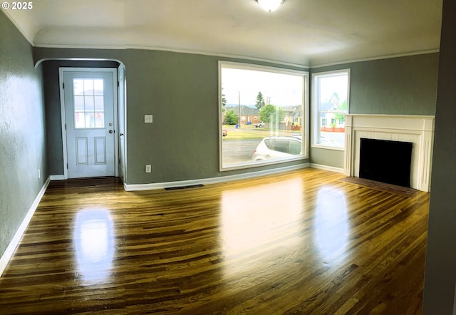 703 Cowlitz Way, Kelso, WA 98626 - unfurnished living room featuring a fireplace with flush hearth, crown molding, wood finished floors, arched walkways, and a textured wall