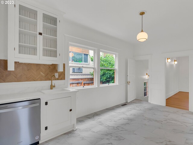 kitchen featuring sink, pendant lighting, light tile floors, dishwasher, and white cabinetry