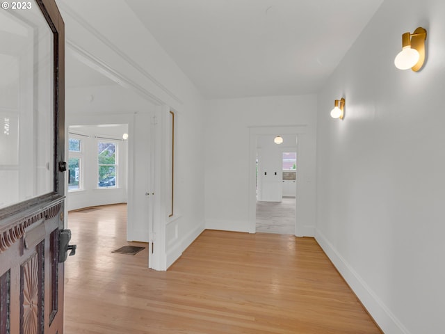 hallway with light hardwood / wood-style floors