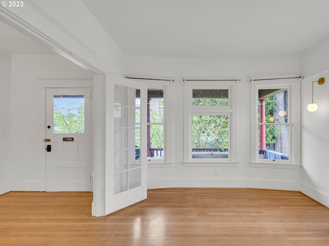 unfurnished room featuring french doors and light wood-type flooring