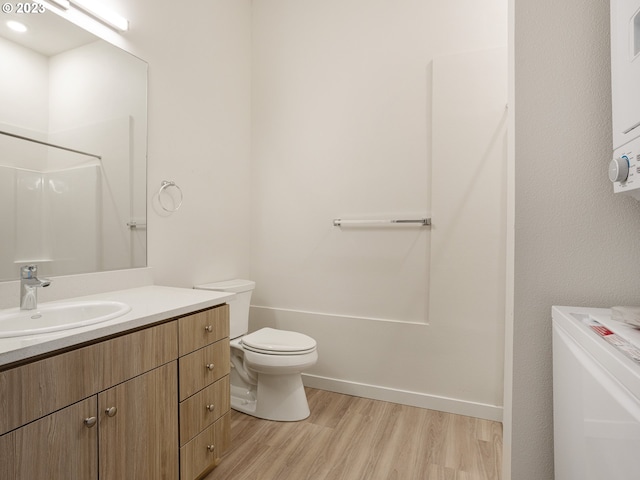 4738 SE Belmont St, Portland, OR 97215 - bathroom featuring vanity, washer / dryer, hardwood / wood-style floors, and toilet