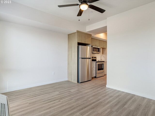 4738 SE Belmont St, Portland, OR 97215 - kitchen with appliances with stainless steel finishes, ceiling fan, light brown cabinetry, and light wood-type flooring
