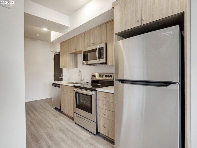 4738 SE Belmont St, Portland, OR 97215 - kitchen featuring light brown cabinets, light wood-type flooring, sink, and stainless steel appliances