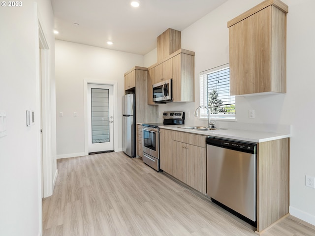 4738 SE Belmont St, Portland, OR 97215 - kitchen with appliances with stainless steel finishes, light brown cabinetry, light hardwood / wood-style flooring, and sink