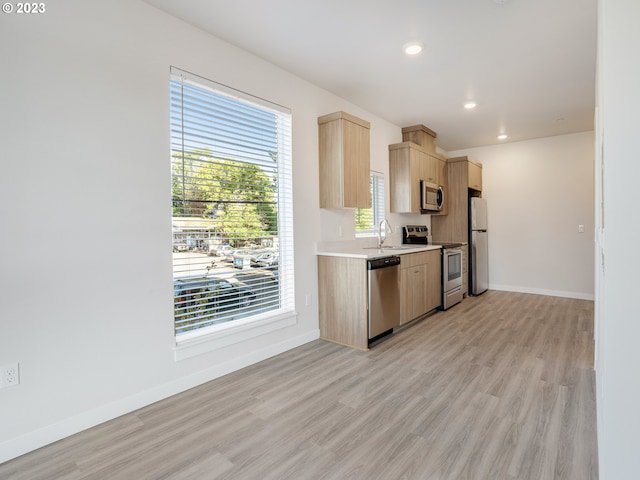 4738 SE Belmont St, Portland, OR 97215 - kitchen featuring sink, appliances with stainless steel finishes, light brown cabinetry, and light wood-type flooring